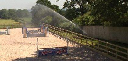 Automated horse menage watering system consisting of large sprinklers located around the perimeter fencing, pump and tank and controller