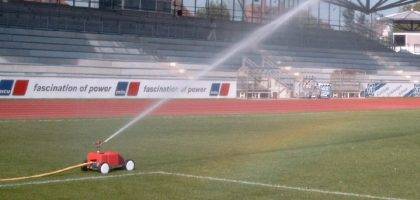Watering a football pitch with travelling sprinkler