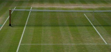 Grass tennis court watered using tennis court irrigation system