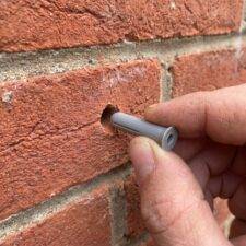 Wall pin plug being inserted into a hole