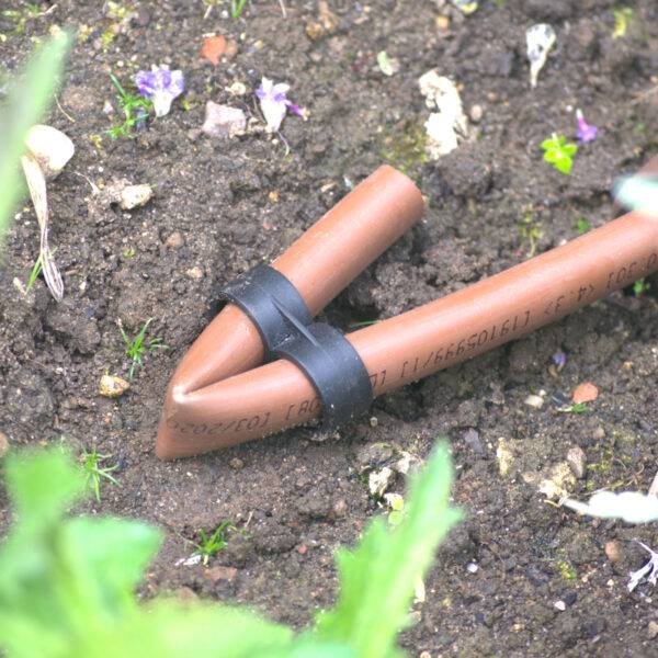 Permadrip Pro drip pipe with stopend laying on the ground of garden border