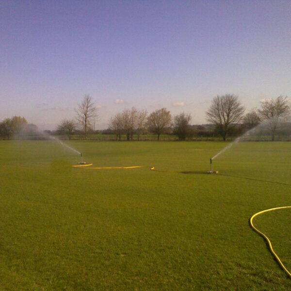Temporary sprinklers watering sports pitch