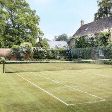 Grass tennis court at a house watered using tennis court irrigation system