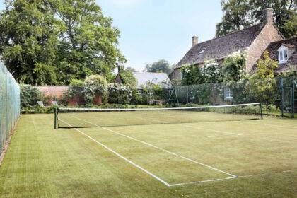 Grass tennis court at a house watered using tennis court irrigation system