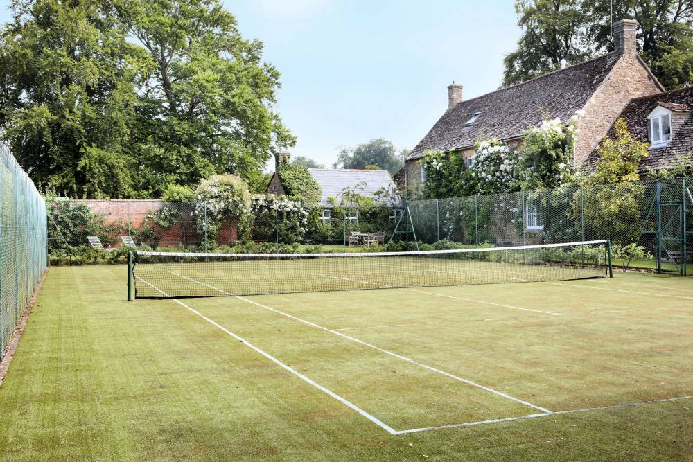 Grass tennis court at a house watered using tennis court irrigation system