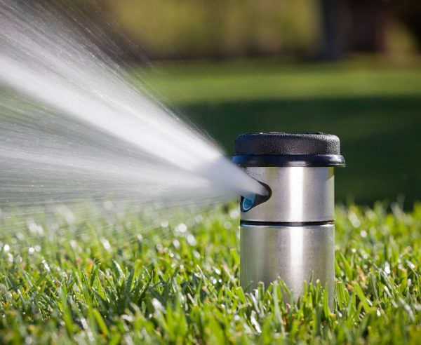 Image of Hunter I-40 pop-up sprinkler operating, watering grass sport area