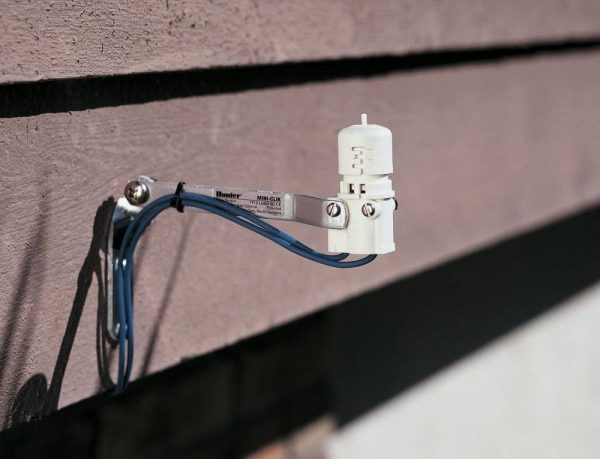 Hunter Mini Clik rain sensor in use mounted to a wooden fence